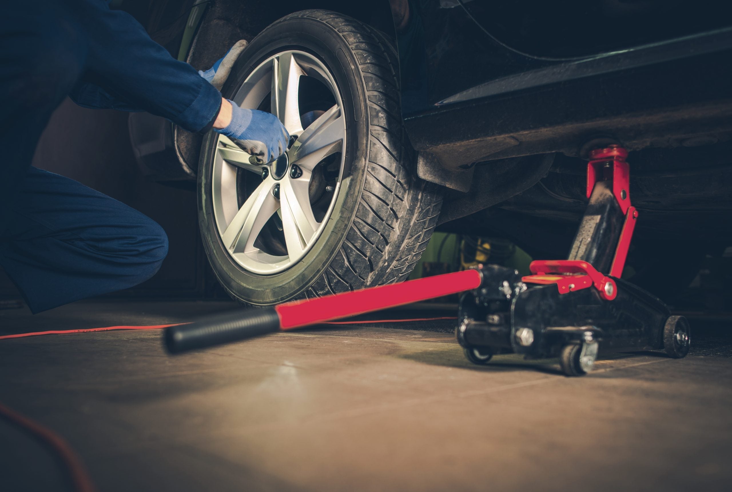 Mechanic servicing a car wheel for Chevrolet tire alignment.